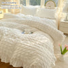 A white lace seersucker duvet cover set including a duvet cover and two pillowcases displayed on a bed.