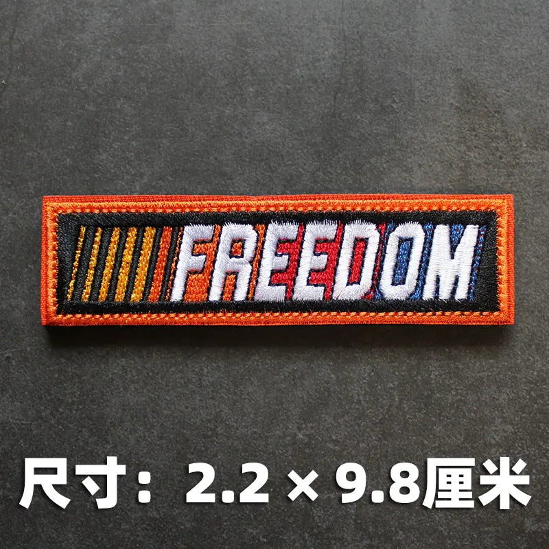 Orange and black hook and loop badge with the word FREEDOM embroidered on it