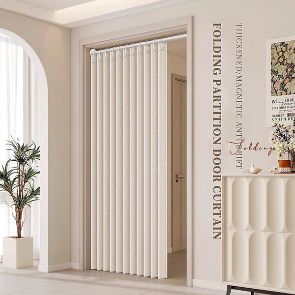 A cream colored folding magnetic partition door curtain installed in a light-colored interior doorway.