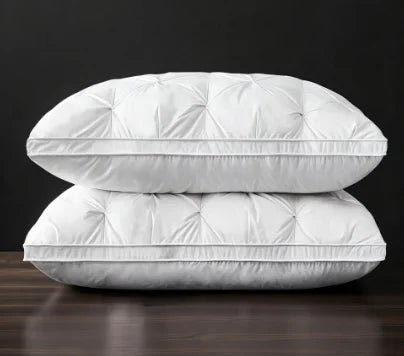A white hotel-grade memory foam sleeping pillow lying on a dark wooden surface.