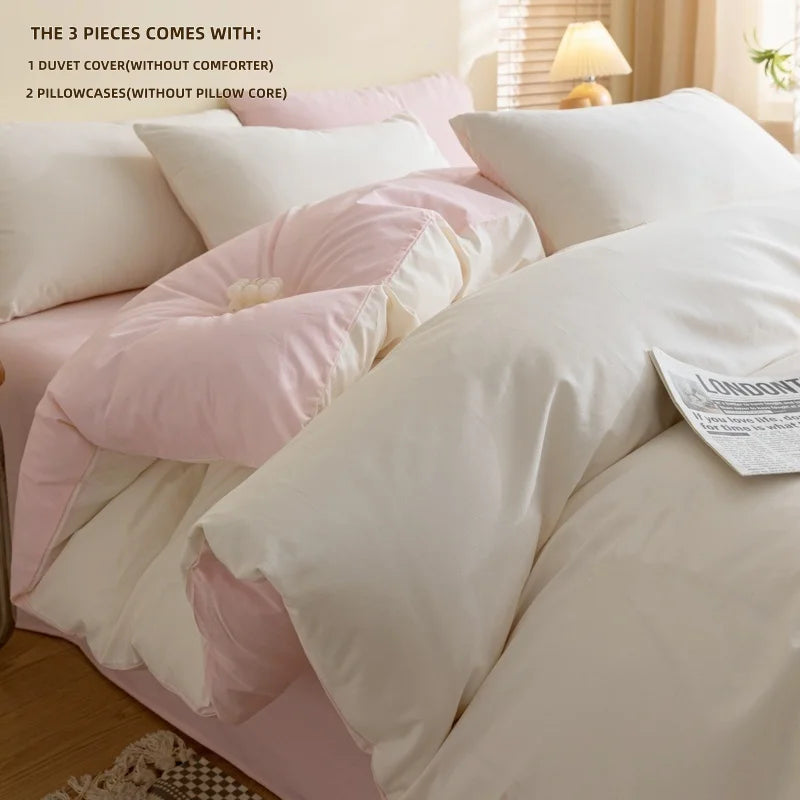 A close-up of a pink and white duvet cover set with two pillowcases on a bed.