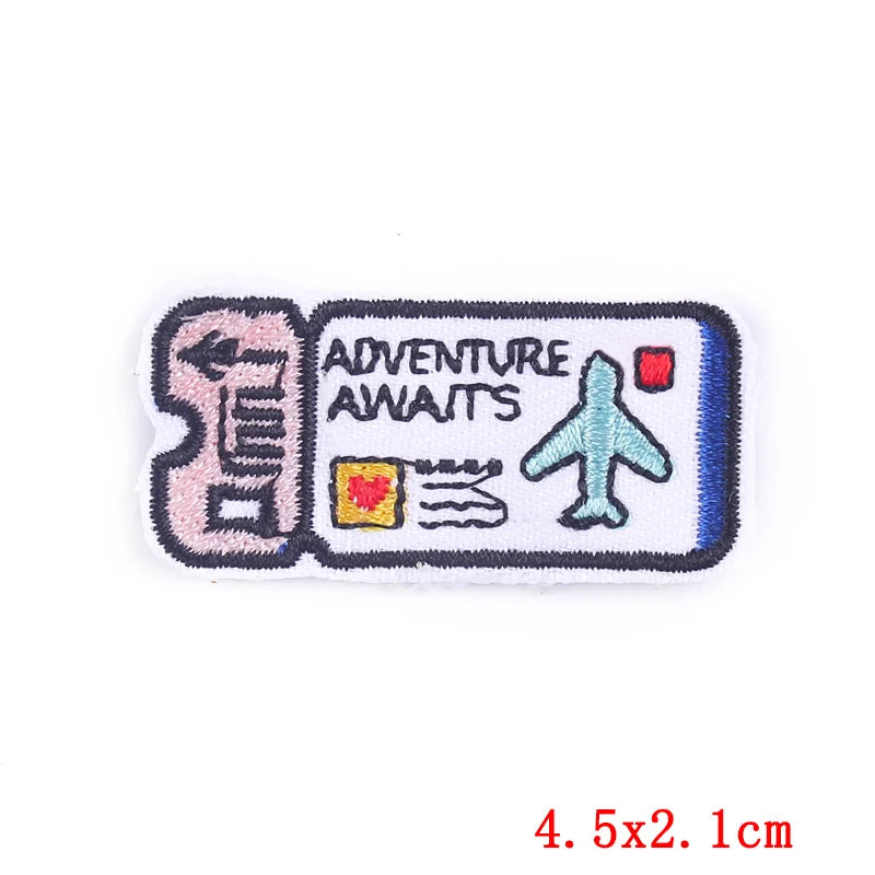 Pink embroidered iron-on patch featuring an adventure theme with text and a airplane icon