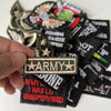A collection of iron-on slogan patches featuring various designs and text on black, green, and gold fabric.