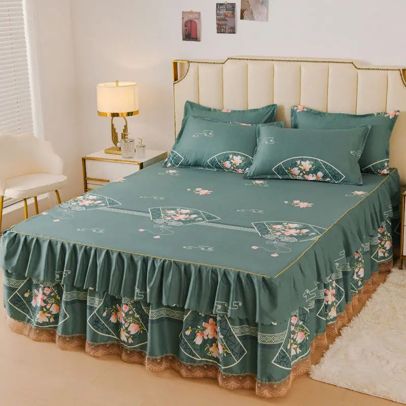 A teal floral bed skirt with ruffled edges covers a bed, positioned in a bedroom setting.