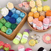 A collection of 12-color soft acrylic yarn balls in various shades of pink, yellow, green, and blue arranged in a wooden bask