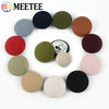 A set of round fabric-covered shank buttons in various colors including black, olive green, terracotta, and pink.