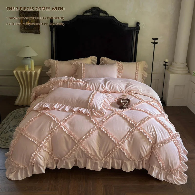 A pink ruffled duvet cover set with three pillows displayed on a bed against a dark headboard.