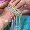 Hand holding multiple strands of glitter metallic yarn in various colors like pink, green, and gold.
