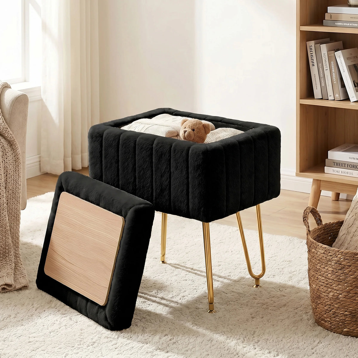A black faux fur ottoman with a wooden lid and gold metal legs sitting on a light rug.