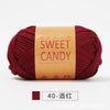A ball of deep red hand-dyed yarn labeled Sweet Candy with Chinese characters.