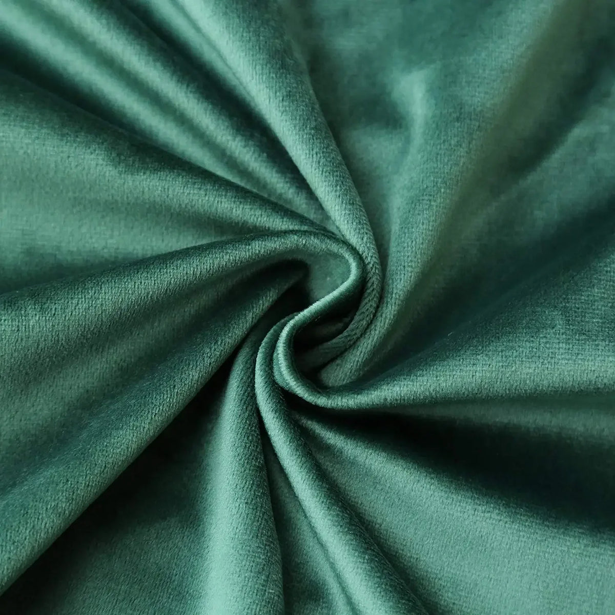 A close-up of a teal velvet throw pillow cover fabric tightly rolled into a swirl.
