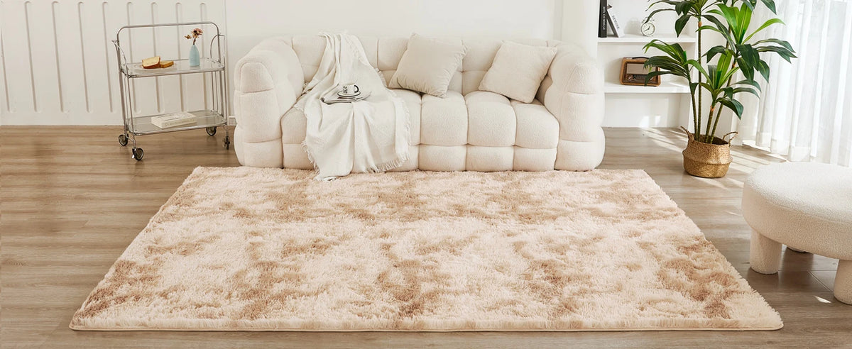 A fluffy cream tie-dye shaggy rug placed on a wooden floor in a bright living room setting.