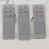Three gray adjustable bra extender straps laid out on a white background.