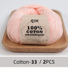 Pink organic cotton yarn skeins on a wooden tray