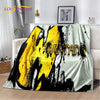 A yellow and black Bat-Man graphic throw blanket draped over a white sofa.