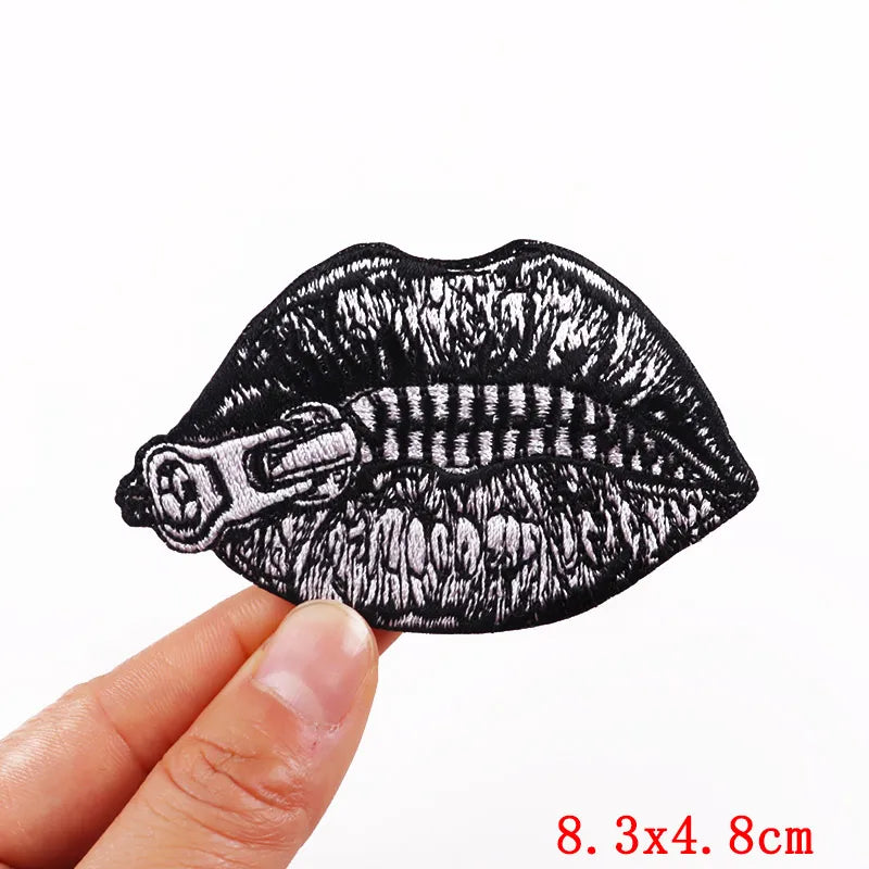 Black embroidery patch depicting a rose skull design on a fabric surface.