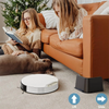 A brown dog rests on a beige carpet in front of an orange leather sofa with a white electronic device for lifting or sliding.