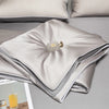 A folded light gray ice silk cooling quilt with a brass zipper visible on the top layer.