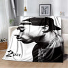 A black and white graphic print of a man's profile on a throw blanket.