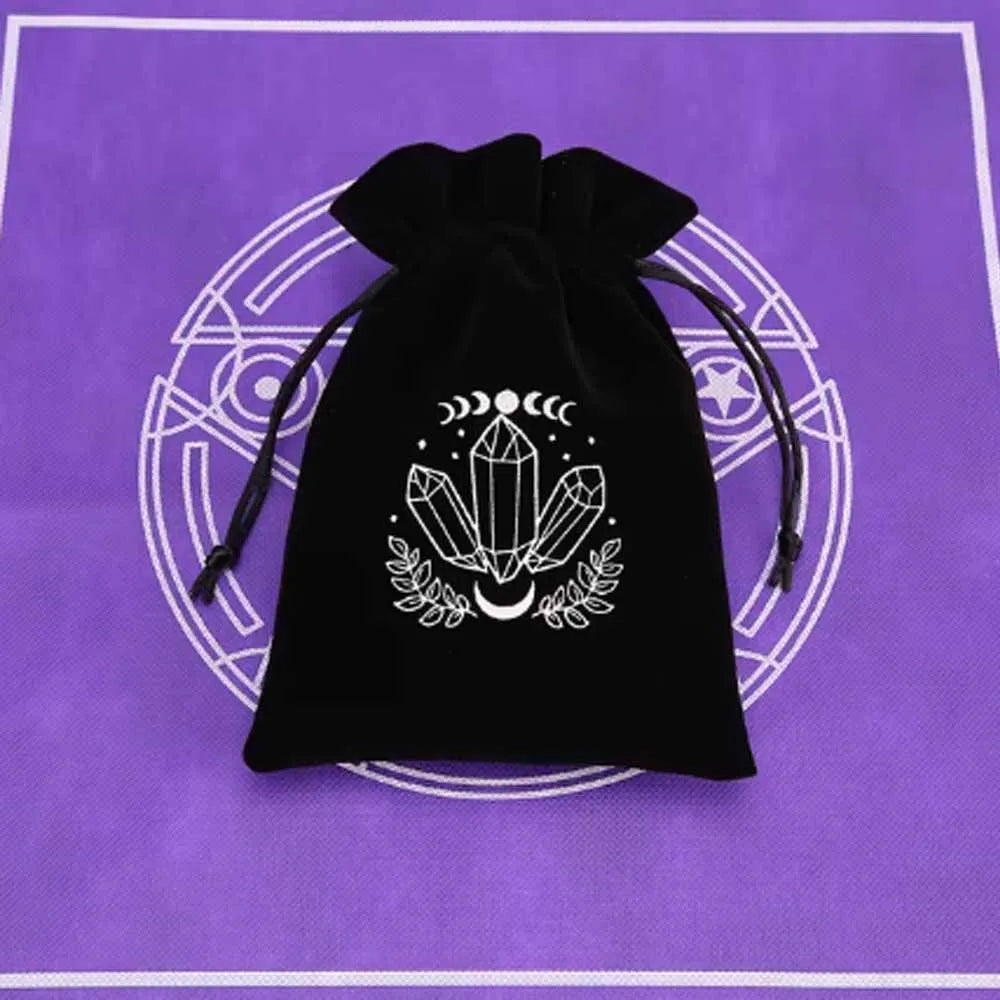 A black velvet tarot cards storage pouch with white celestial symbols embroidered on the front, set against a purple backgrou