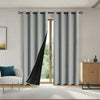 Gray blackout window curtains hanging in a modern room with natural light.