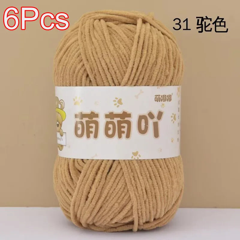 A skein of 6 pieces of soft bulky chenille yarn in a light tan or beige color.