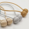 A set of minimalist magnetic ball curtain tiebacks in gold, silver, and beige tones.