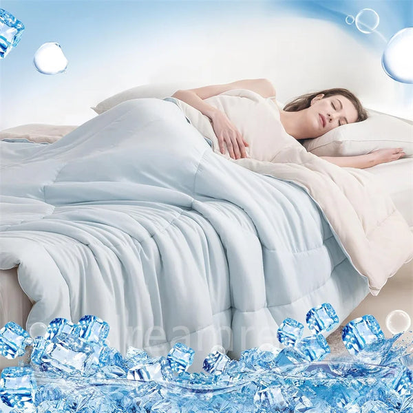 A woman is sleeping comfortably under a white reversible cooling quilt with blue ice cubes scattered on the bedding.