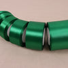 A roll of vibrant green satin ribbon for crafting and decoration, shown in a row.