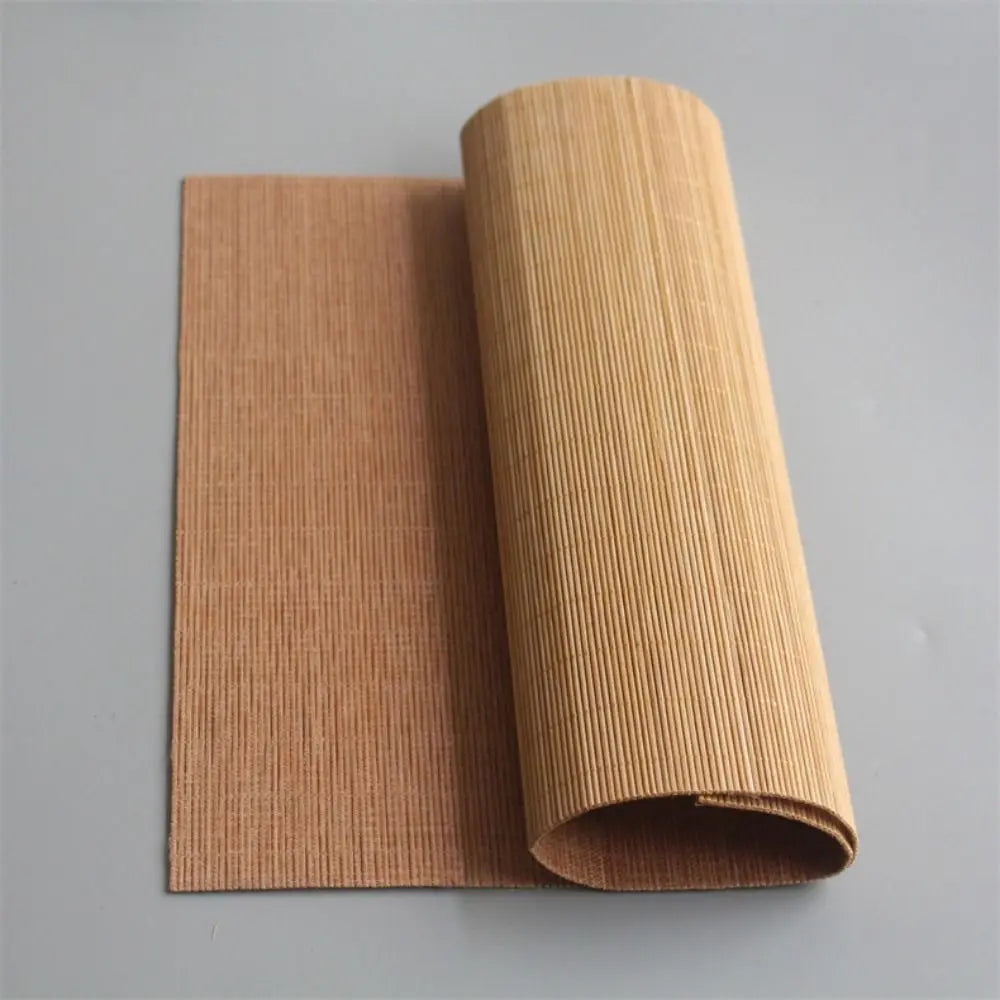 A roll of hand-woven multicolor bamboo tea mat material in a natural tan color.