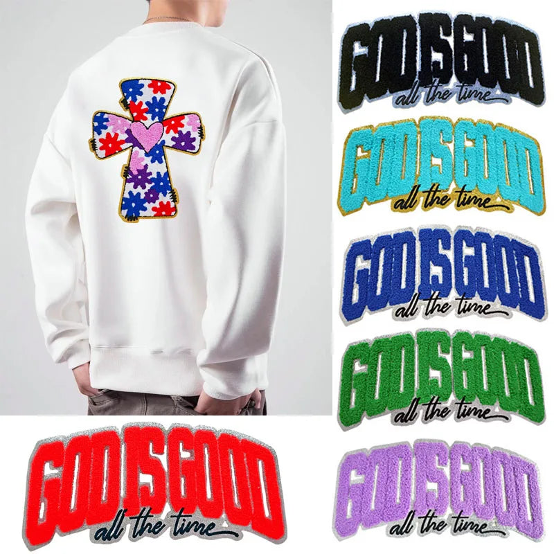 A white sweatshirt features multiple embroidered patches with the text God is good all the time in various colors.