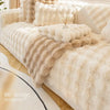 A luxurious beige plush rabbit fur sofa cushion cover draped over a light-colored sofa.
