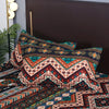 A close-up of a Boho Geometric duvet cover set featuring intricate patterns in earthy tones like rust, teal, and navy blue.