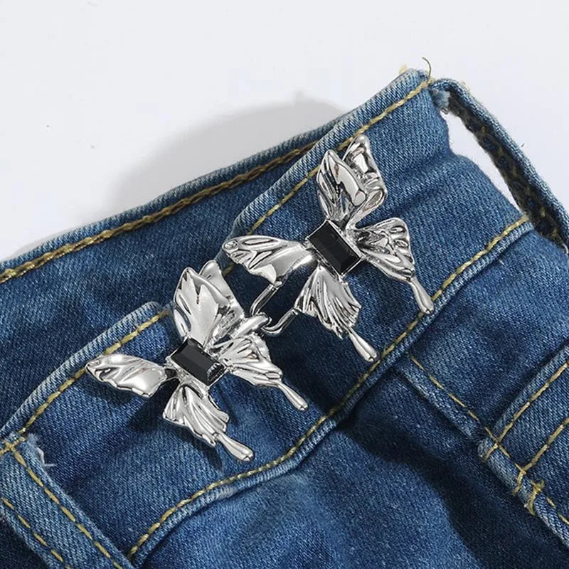 Silver floral brooches clipped onto a denim jean fabric
