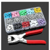 A plastic tray holds various colorful metal sewing buttons in different shades of blue, pink, green, and yellow.