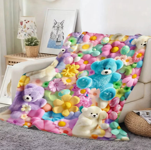 A colorful flannel blanket featuring a floral print with various teddy bears and flowers.