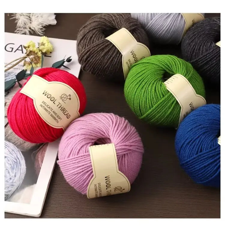 A collection of various colored wool thread and yarn skeins displayed on a dark surface.