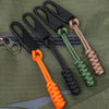 A collection of detachable zipper pull sliders in various colors and materials attached to a green fabric background.