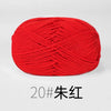 A ball of bright red organic cotton 4ply knitting yarn.