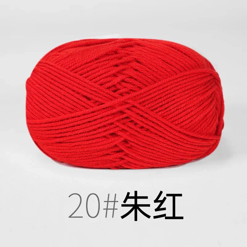 A ball of bright red organic cotton 4ply knitting yarn.
