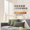 A light gray sofa with olive green cushions and a matching throw, displayed in a bright room.