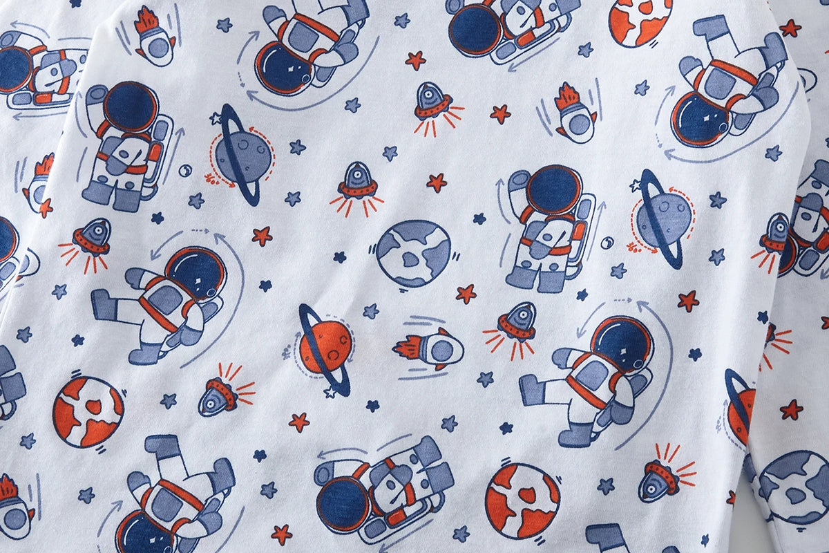 A white pajama set featuring a repeating pattern of cartoon astronauts and stars.