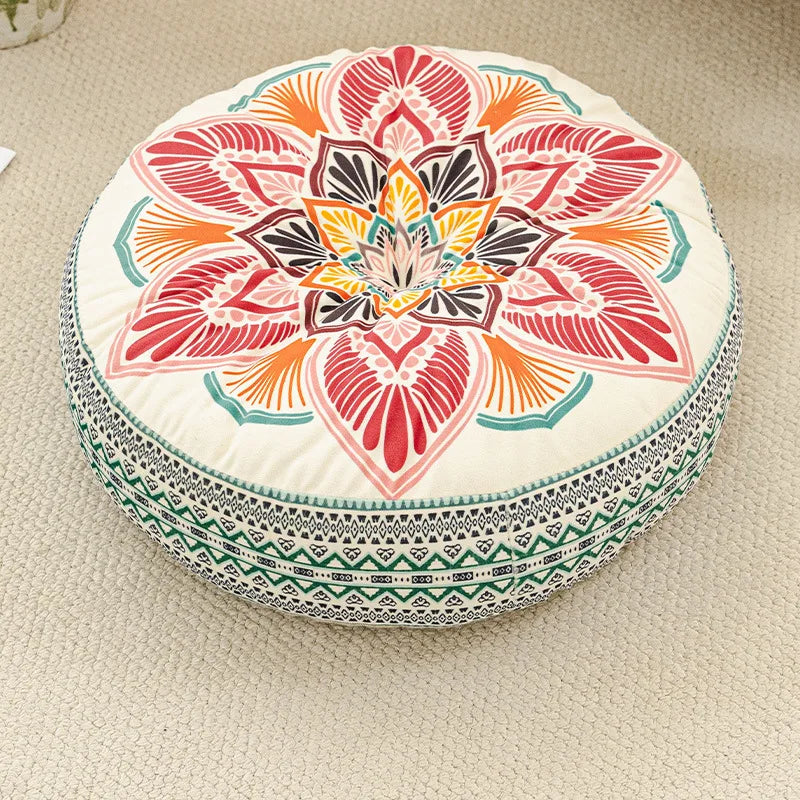 A round bohemian tatami cushion featuring a colorful floral pattern in shades of orange, pink, and white.