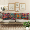 A sofa decorated with a set of colorful boho chic mandala plaid pillow covers and framed art on the wall.
