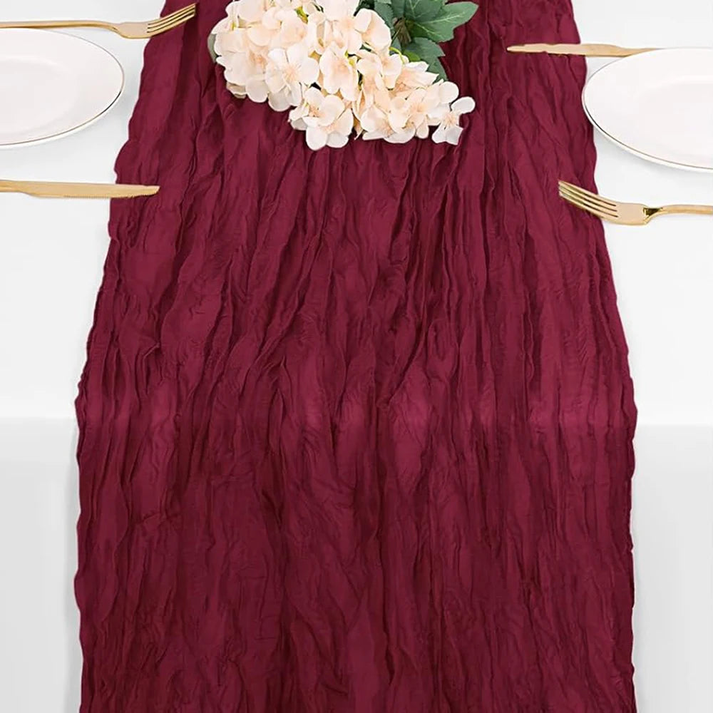 Burgundy cheesecloth table runner with white flowers and gold cutlery for rustic decor
