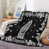 Black tapestry blanket featuring a white floral and star pattern.