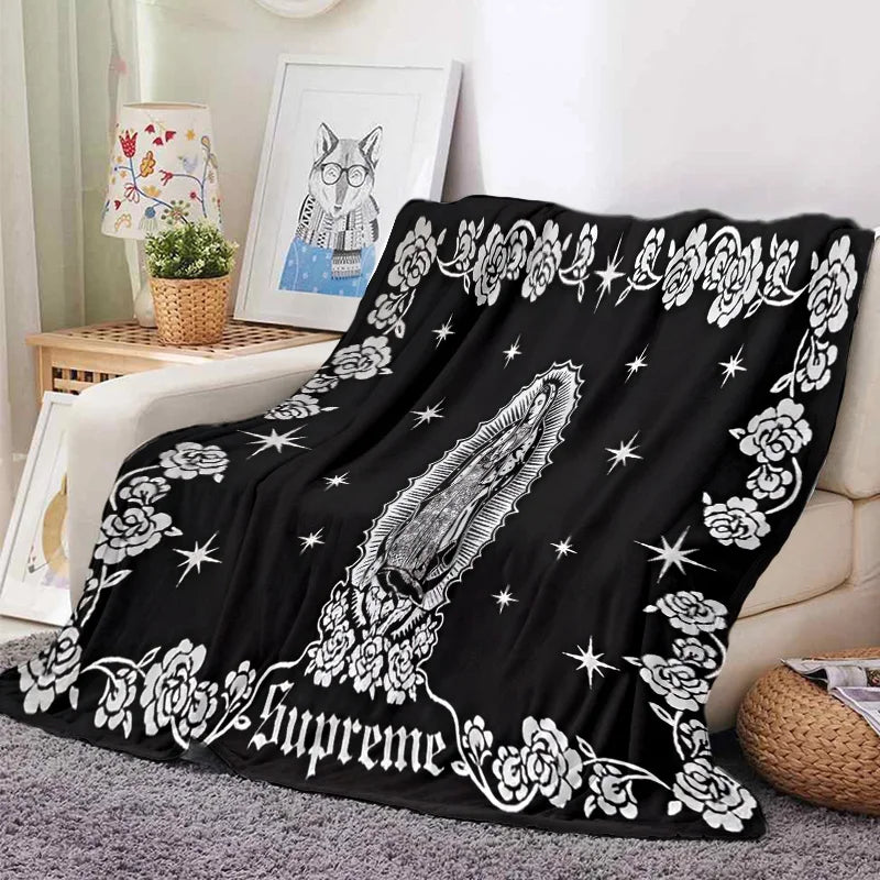Black tapestry blanket featuring a white floral and star pattern.
