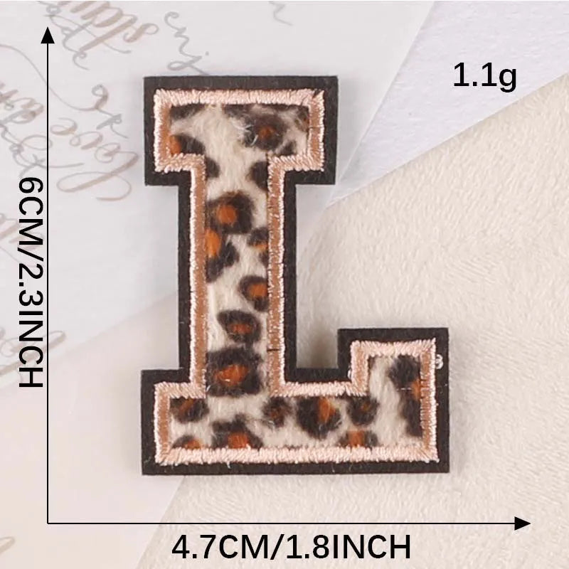A black iron-on patch shaped like the letter L with a leopard print design.
