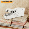 A white compact handheld electric sewing machine lying on a stack of fabric.