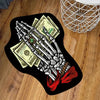 A black design featuring a hand made of cash bills and a red ribbon on a throw rug.